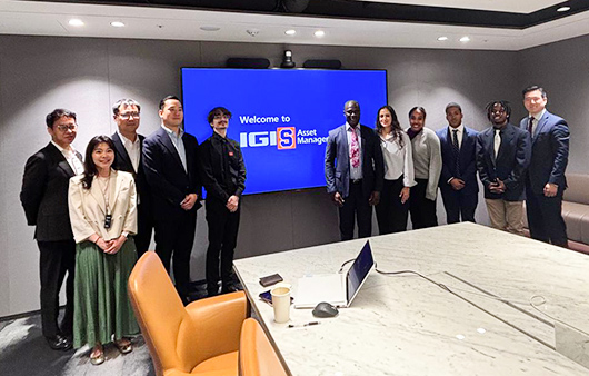 Whitman group posing with the IGIS logo behind them