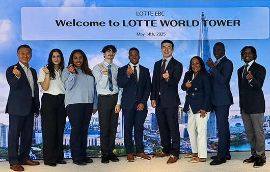 Whitman group posing in front of a Lotte World Tower sign