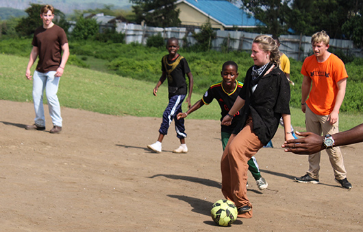 Whitman students playing soccer with kids at the Child Discovery Center