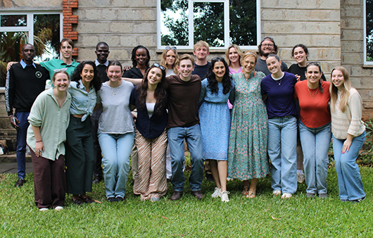 Professor Wimer and students posing in front of brick building