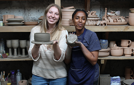 Student showing off pottery at Anchor Leather