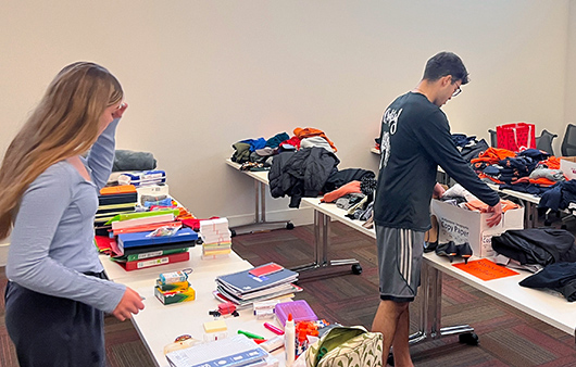 Two students with lots of supplies on tables