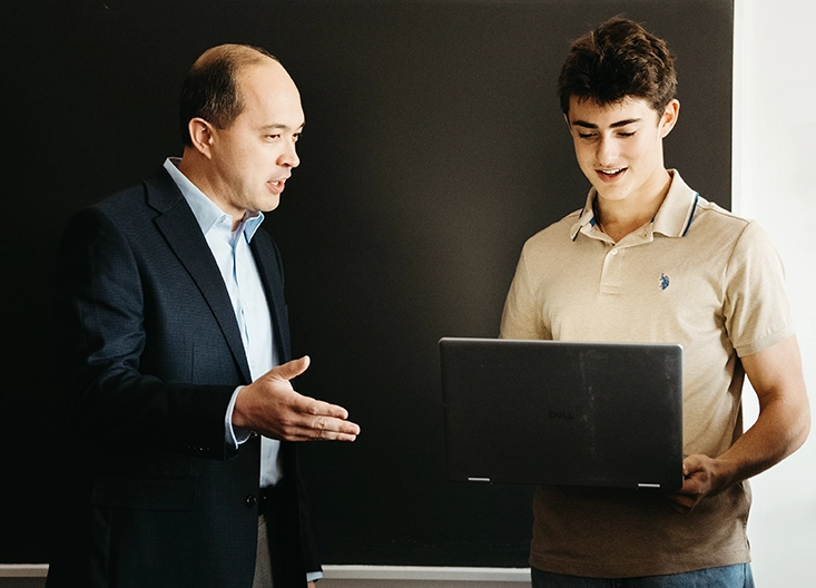 Professor and student looking at laptop