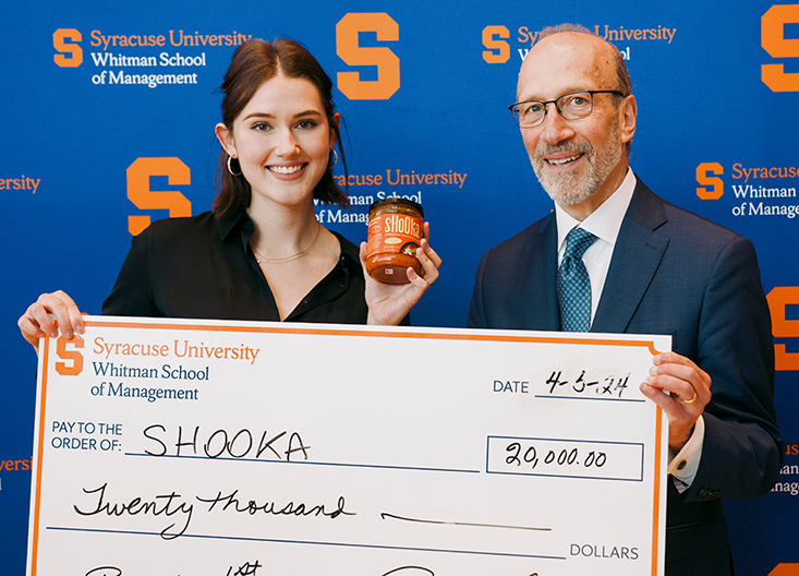 Student posing with oversized check and Mr. Panasci