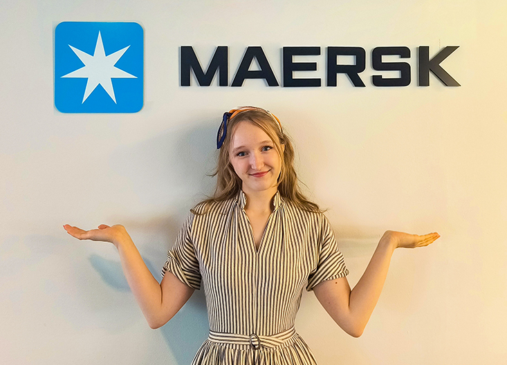 Student posing in front of Maersk sign