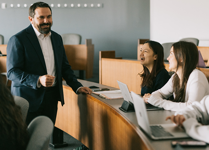 Professor chatting with students in classroom