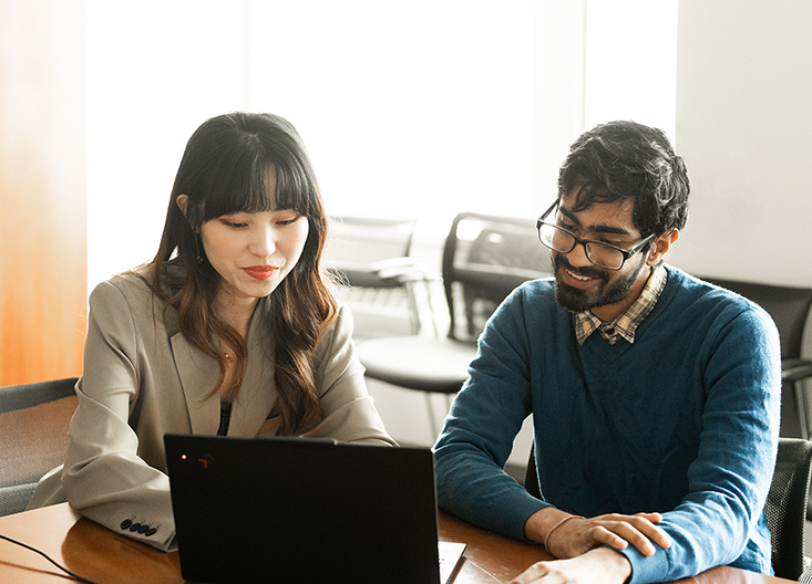 Two students working together on a laptop