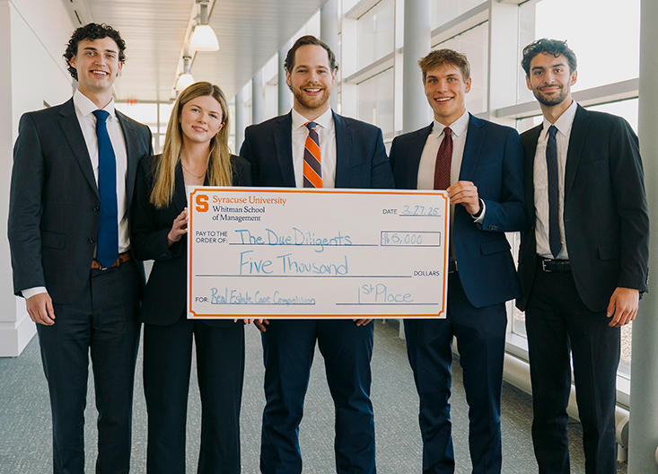 Competition winners posing with oversized check