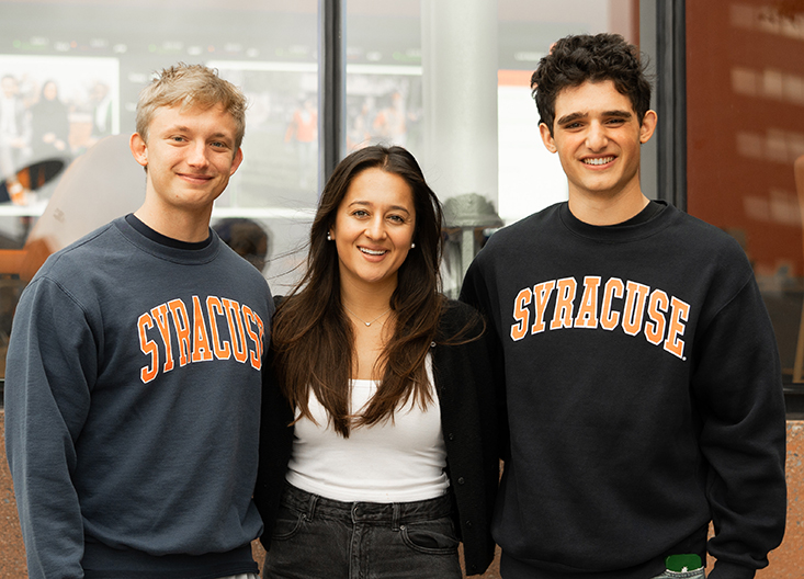 Three students posing outside the Whitman building