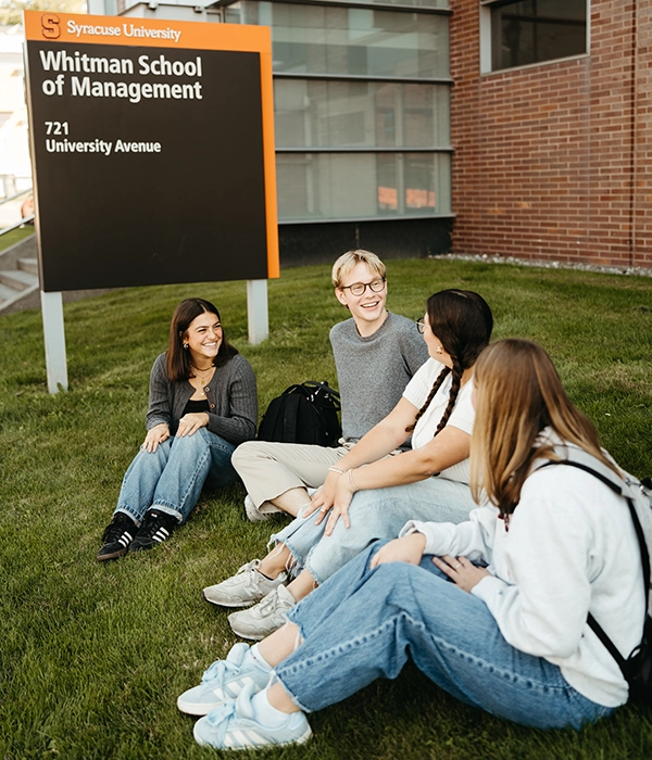 Whitman students sitting in grass outside building