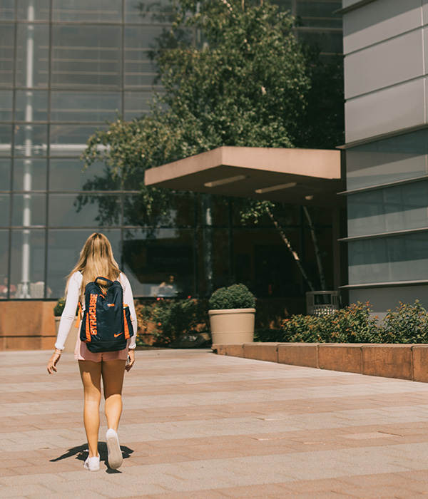 Student walking into the Whitman building on a nice sunny day