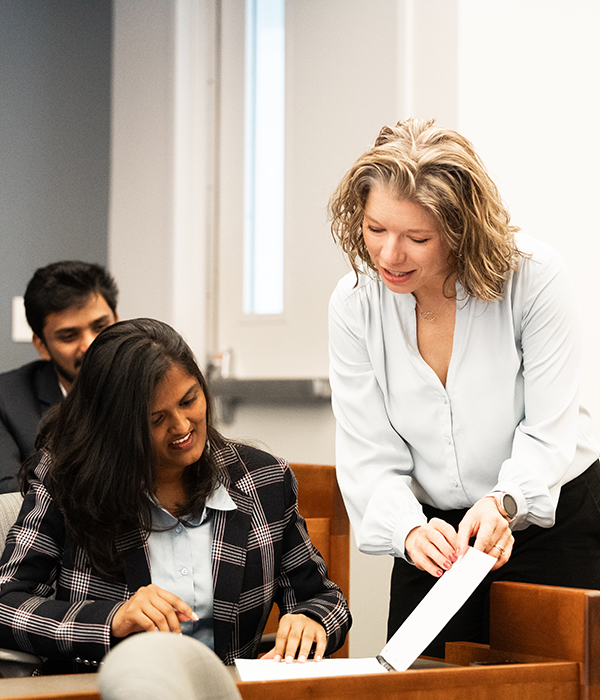 Professor showing student something in a notebook