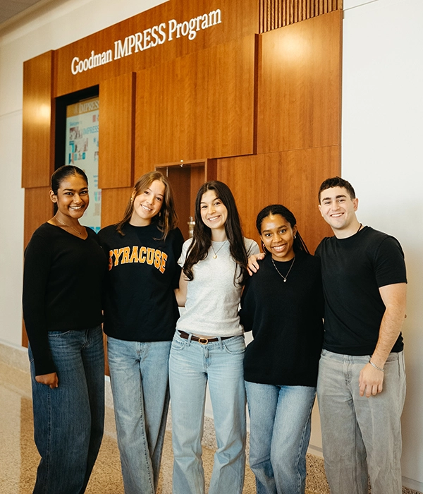 Students posing by IMPRESS program sign