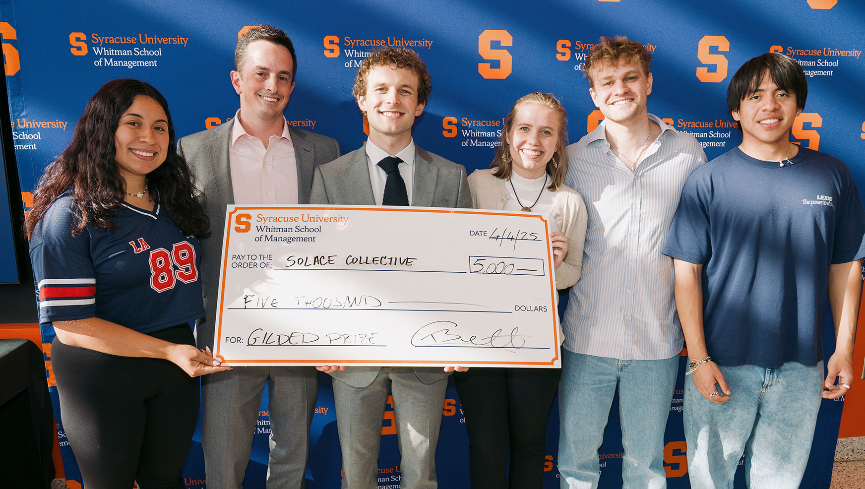 Team Solace posing with oversized check