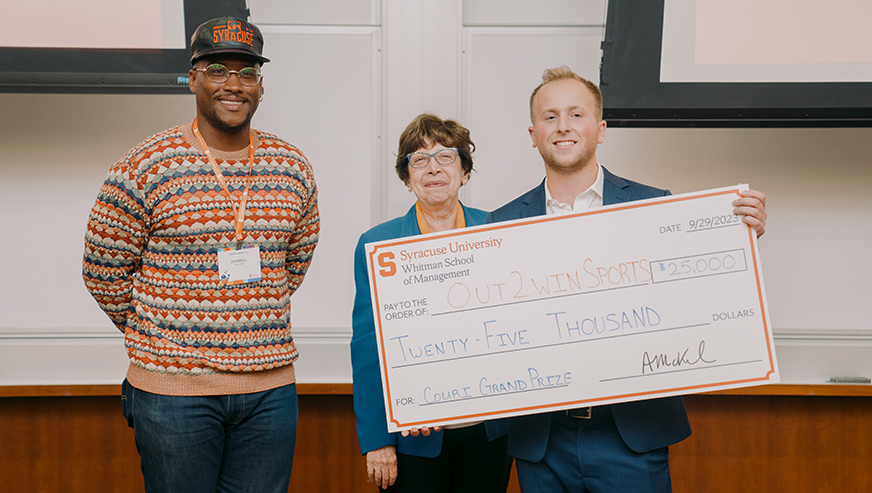 Event emcee, Derrell Smith, Maria Minniti and Jack Adler posing with an oversized check