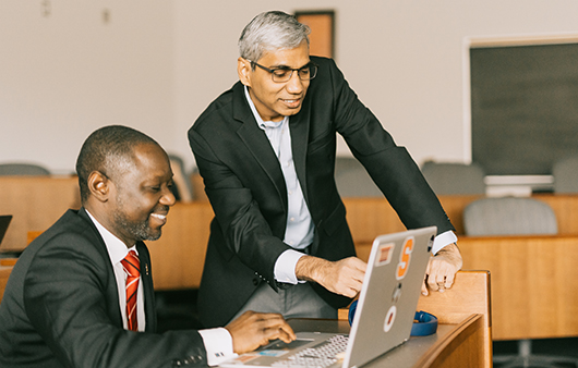 Natarajan Balasubramanian showing a graduate student something on a laptop