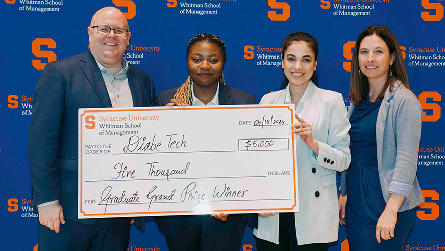 Students Tosin Alabi and Katayoon Faraji posing with their winning check with Dean McKelvie and Erin Draper