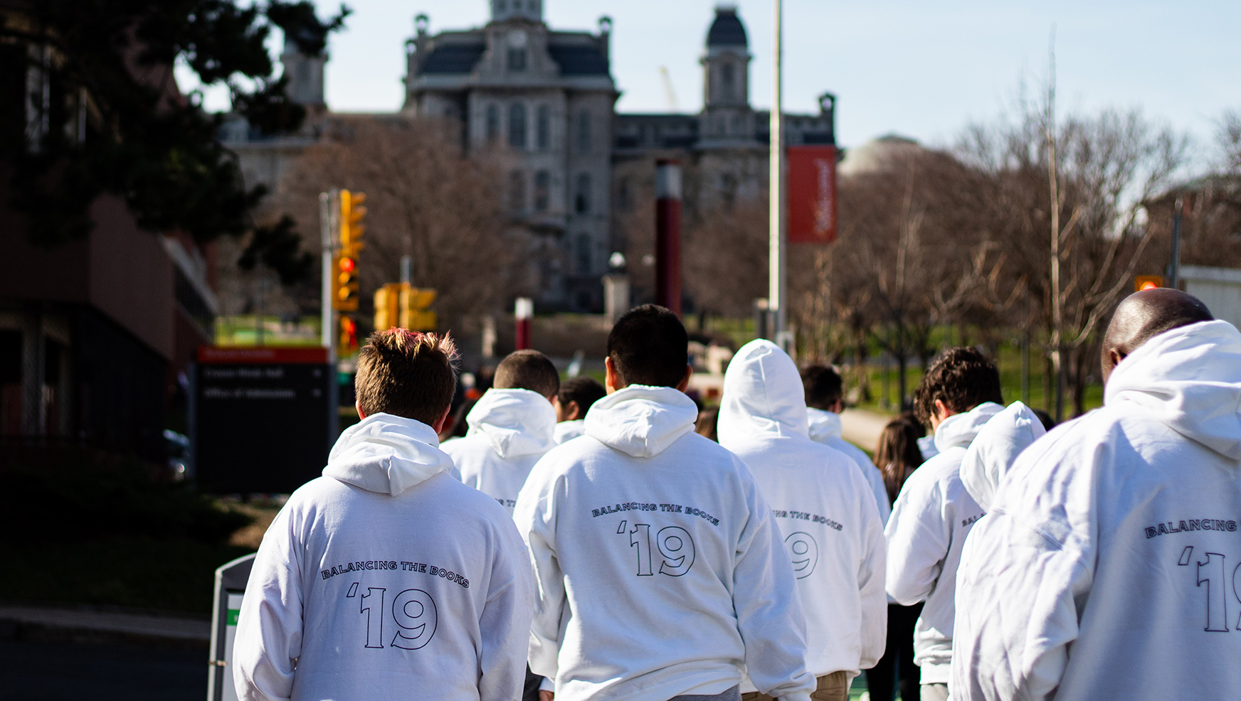 Students wearing Balancing the Books sweaters walking on campus