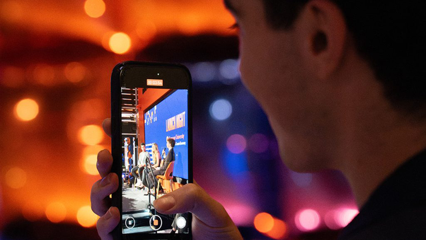 Student looking at the center launch speakers through a cellphone