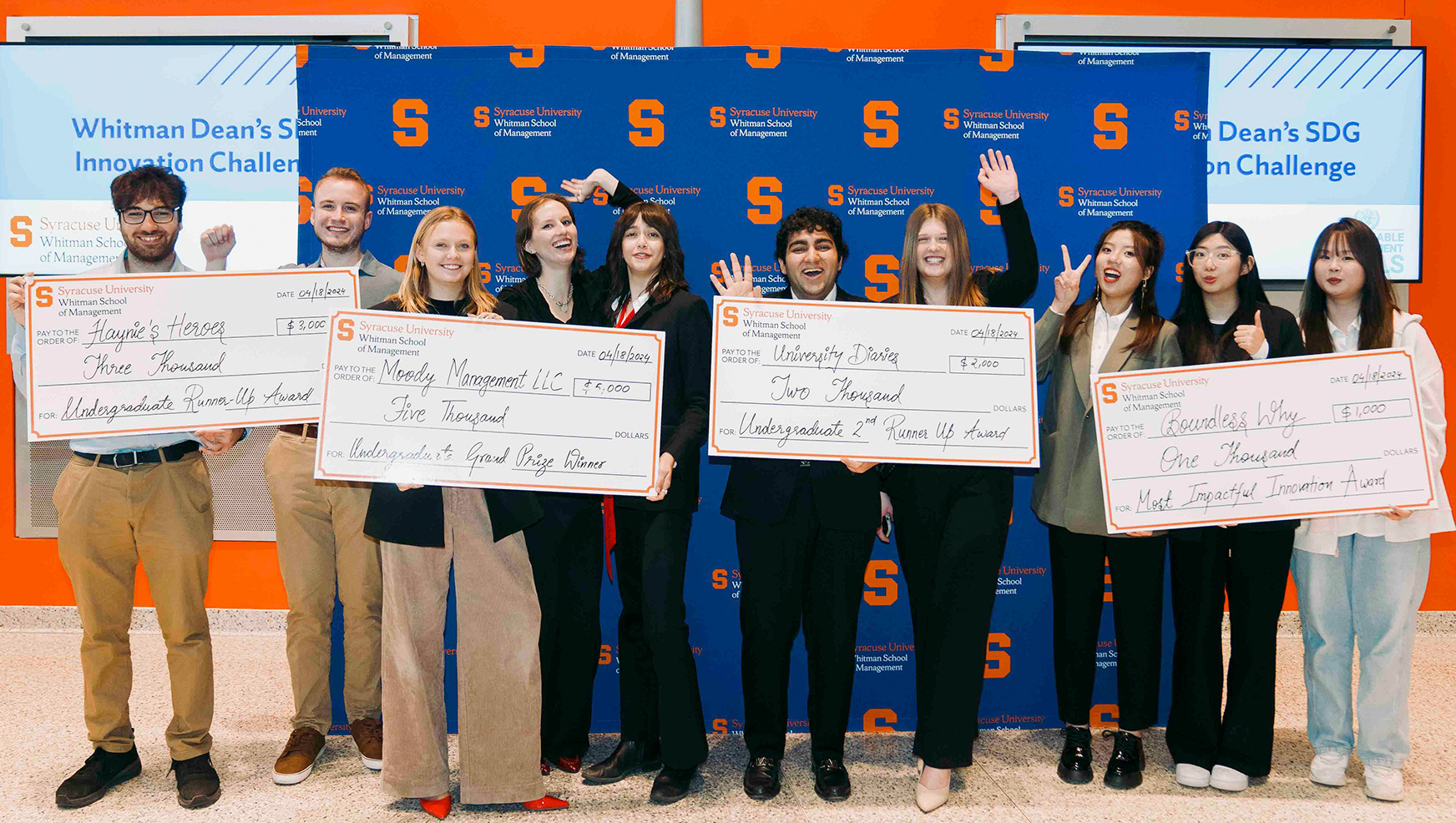 Four student teams posing with their winning checks