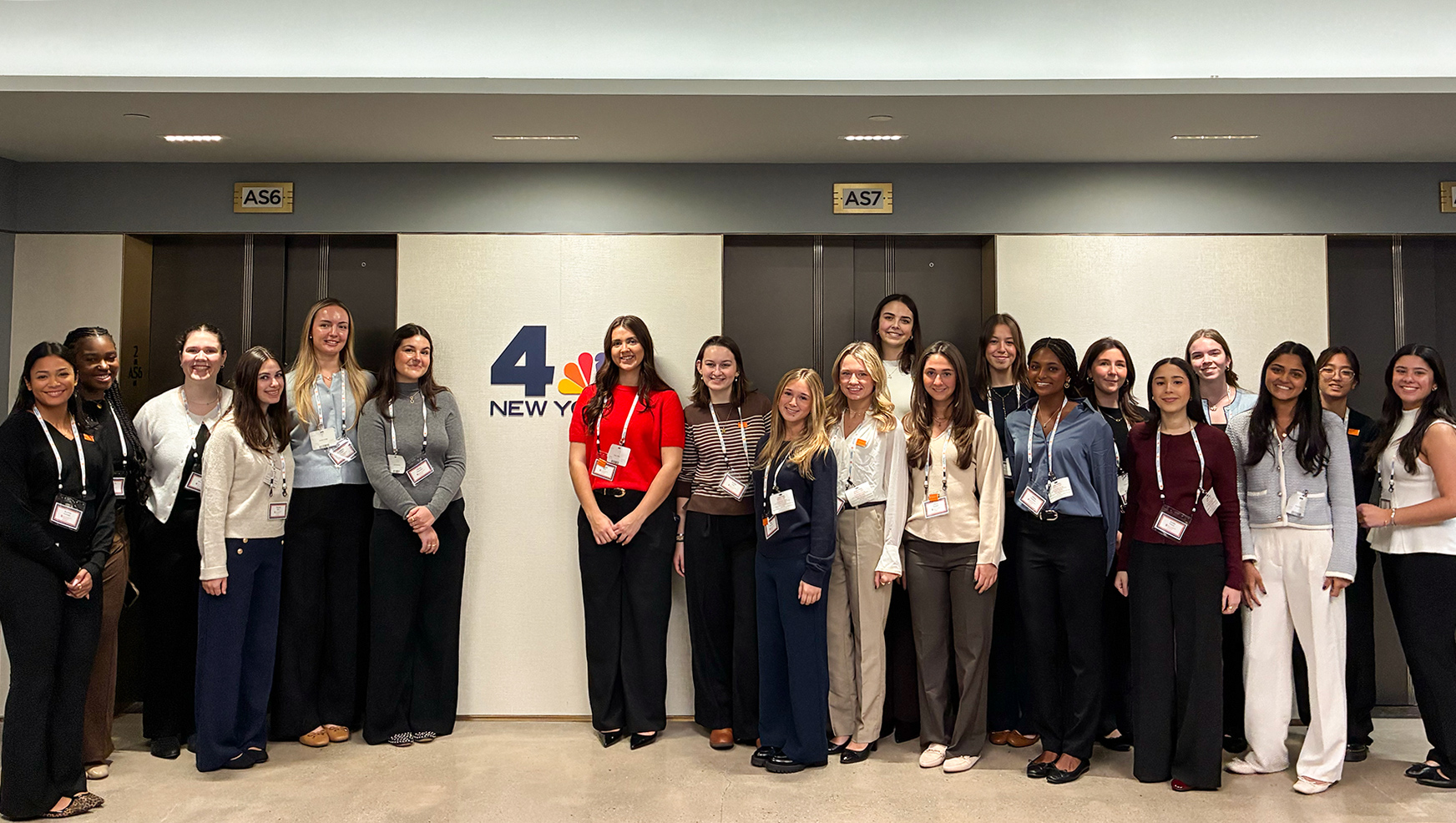 Students posing in front of NBCUniversal logo