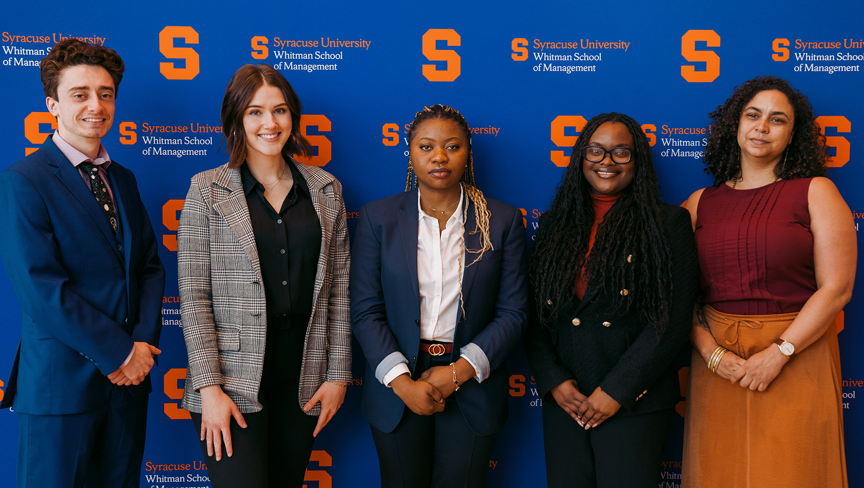 Frank Marin, Natasha Brao, Tosin Alabi, Motolani Oladitan and Jessica Grace McGhee posing in front of Syracuse University banner