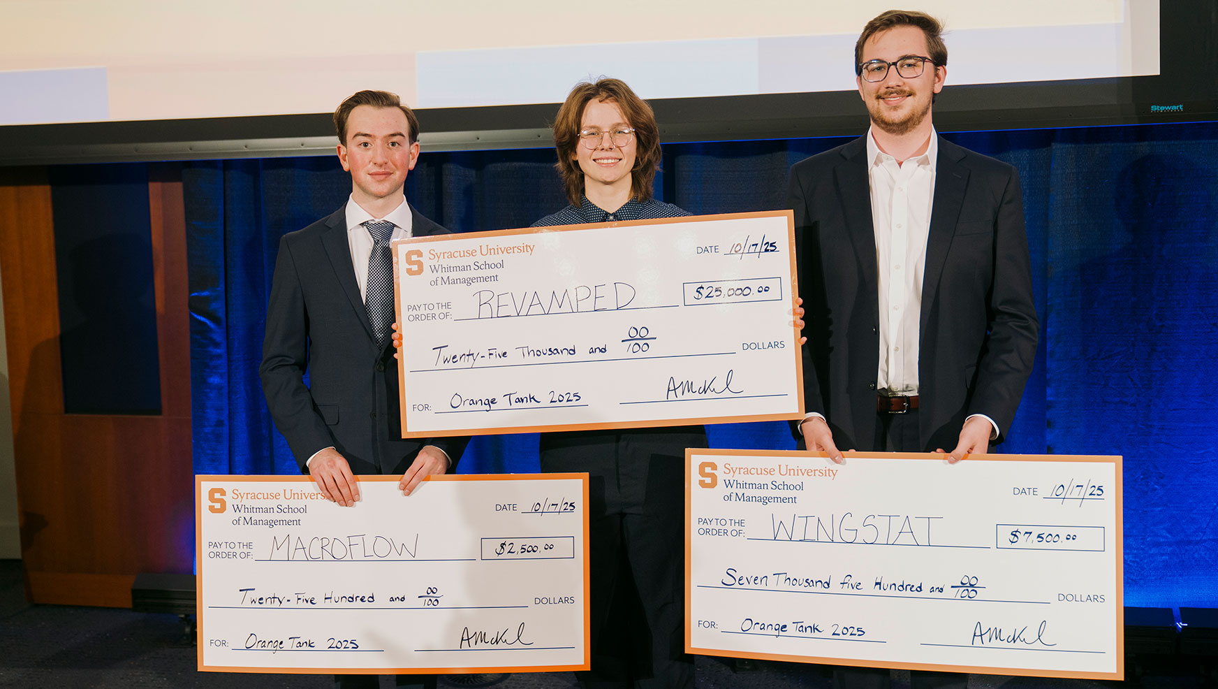 The three Orange Tank 2025 winners posing with their oversized checks