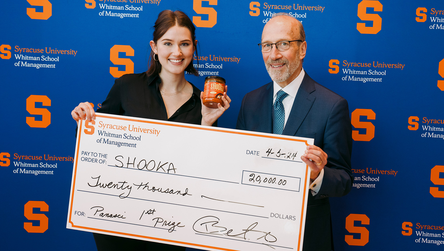 Natasha Brao posing with her winner check next to David Panasci