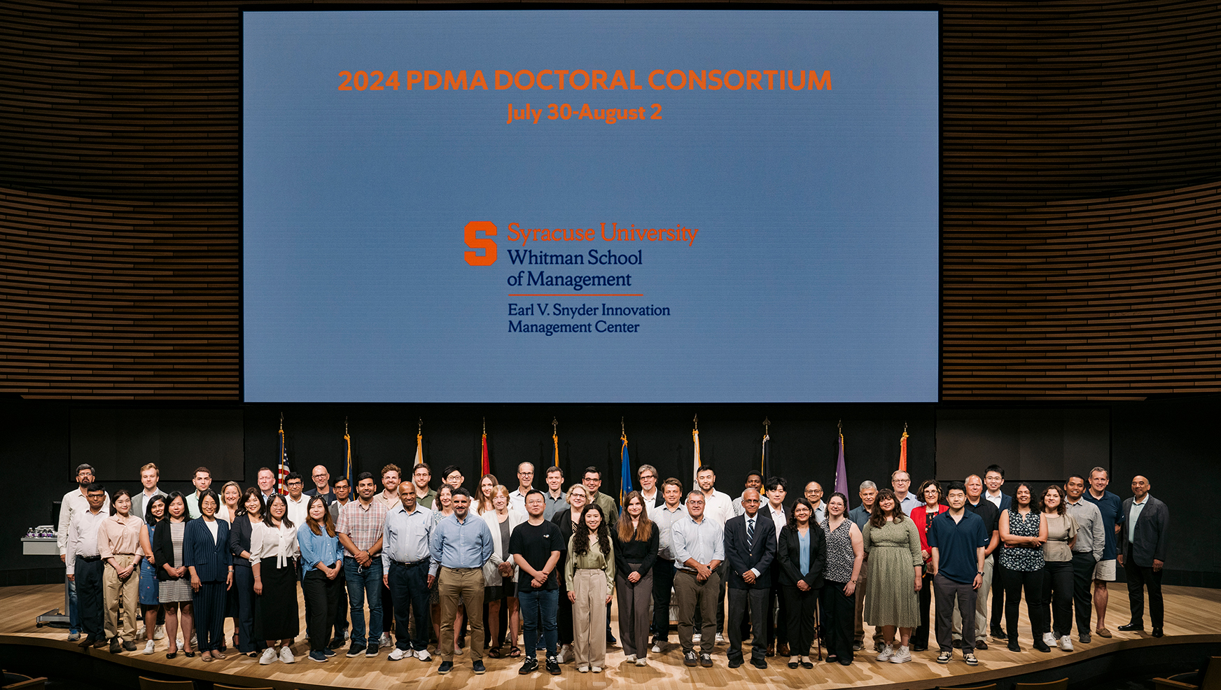 Participants posing in front of 2024 PDMA screen