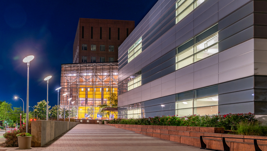 The Whitman School of Management building on a summer evening.