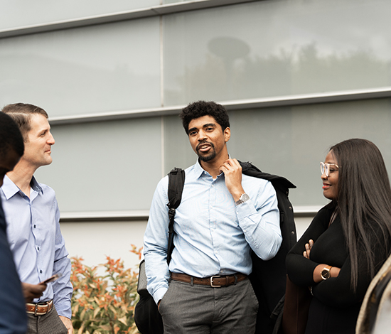Group of graduate students chatting outside Whitman
