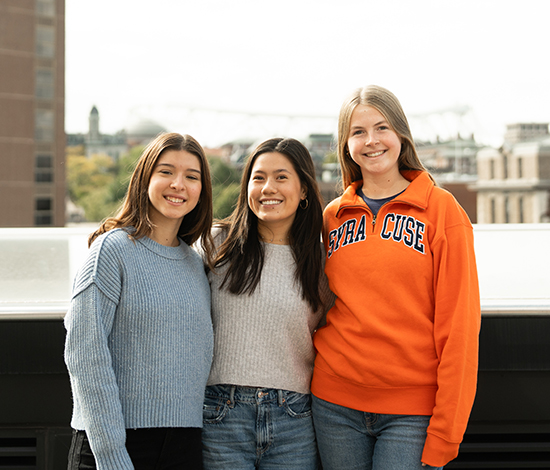 Three undergrad students posing on the Whitman terrasse with campus in the background