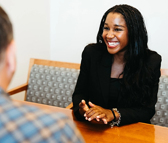 Student smiling while meeting with advisor