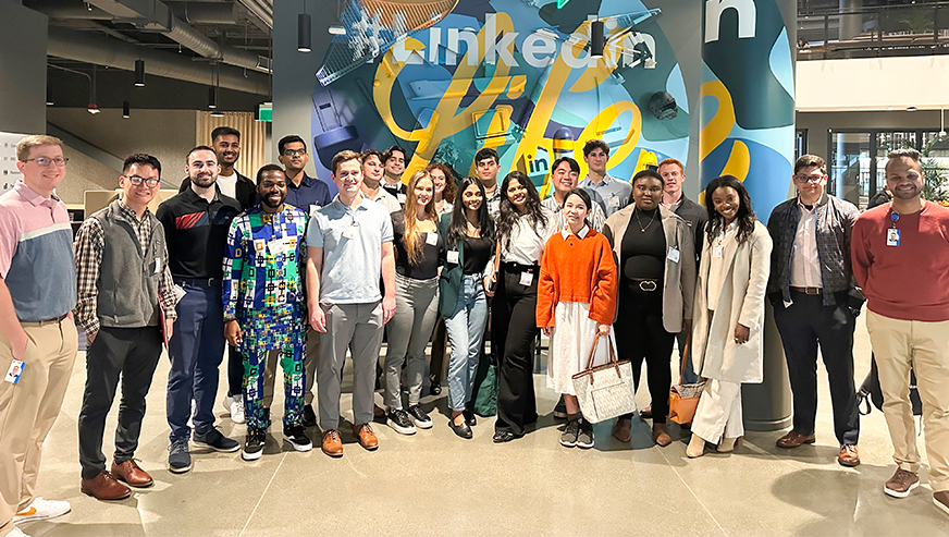 Students posing in front of the LinkedIn logo