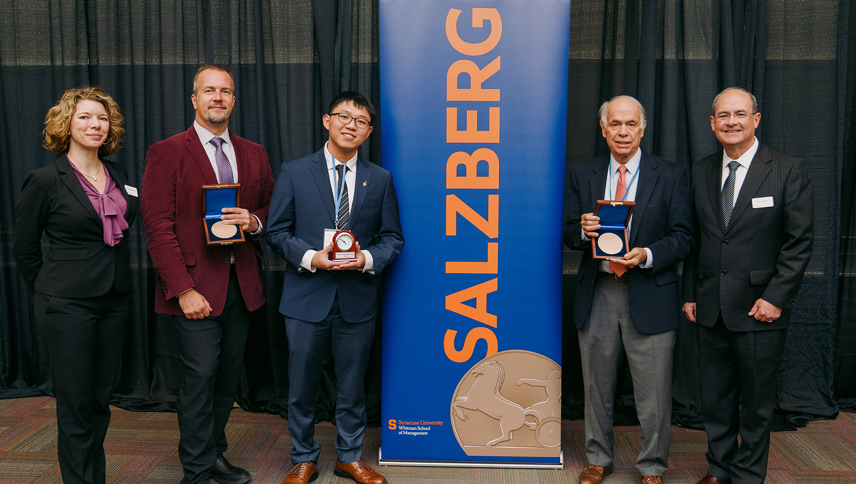 Julie Niederhoff, Michael Kuligowski, Chieh-Shen Jason Lai, Marshall Fisher and Gary LaPoint posing next to a Salzberg banner