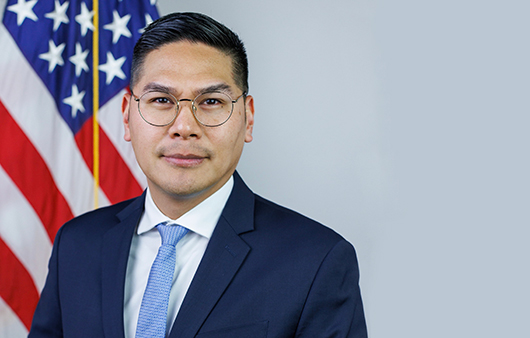 Gabriel Uy posing in front of American flag