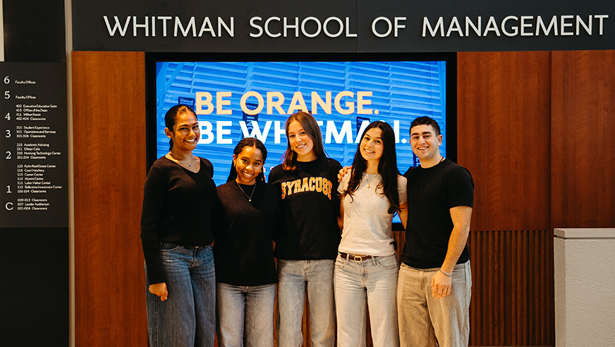 Students posing in front of sign saying Whitman School of Management
