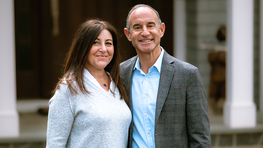 Dina and David Nass in front of their home